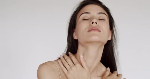 Glamorous Young Woman Massaging Shoulders in Close Up