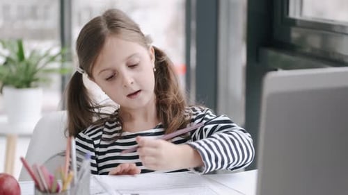 Menina estudando com vídeo, aula on-line em casa, família isolada