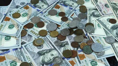 Coins Falling on Pile of American Money