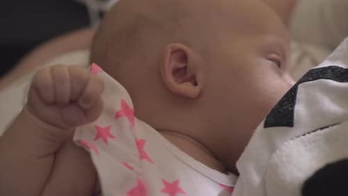 Content Baby Resting Peacefully in Someone's Arms