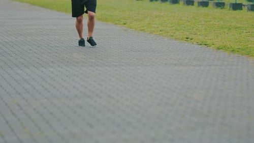 Legs of a Man Running Along the Path
