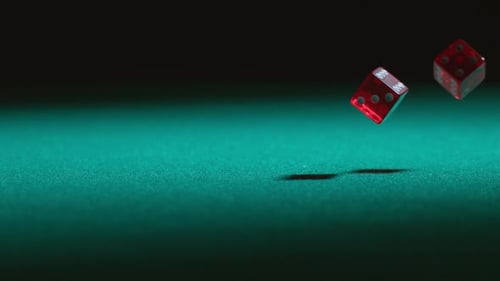 Red Dice Rolling on Green Gaming Table