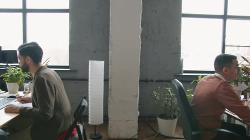 Zoomout of Open Space Office Room and People Employees Working with Computers at Desks