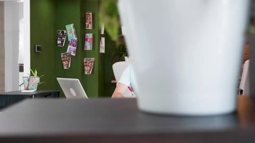 Creative Young Designer Writing Notes and Working on His Laptop at the Office