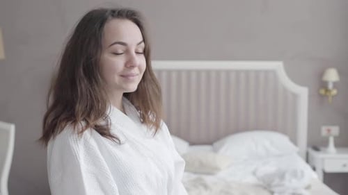 Smiling Brunette Woman Wearing Bathrobe in Bedroom