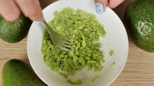 Avocado Being Mashed with Fork in Bowl