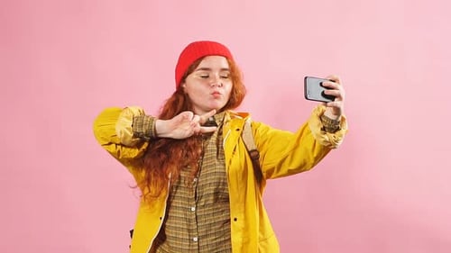 Woman With Red Hair Takes Selfie on Pink Background
