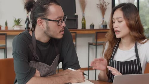 Asian small business owners couple meeting with consultant taking plan and finance in cafe.