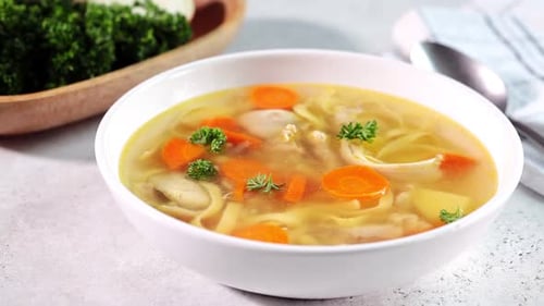 Bowl of Chicken Noodle Soup with Parsley Garnish