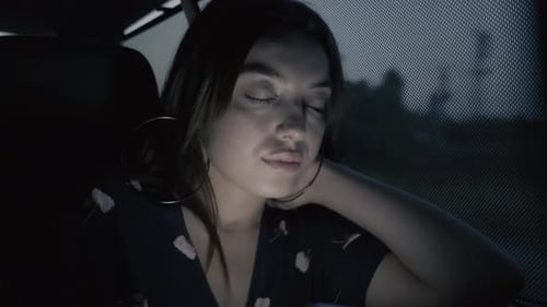 Woman Relaxing in Car at Night with Eyes Closed