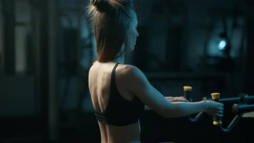 A Pretty Athletic Fit Woman is Doing Exercise on a Fitness Machine in the Gym Training Full Body