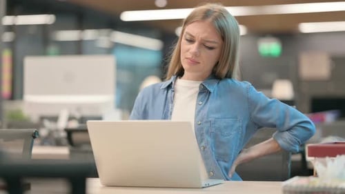 Woman Having Back Pain While Using Laptop in Office