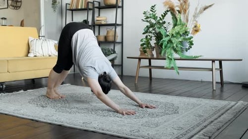 Woman Does Yoga Poses on Rug Inside