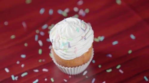Cupcake with Frosting and Sprinkles on Wood