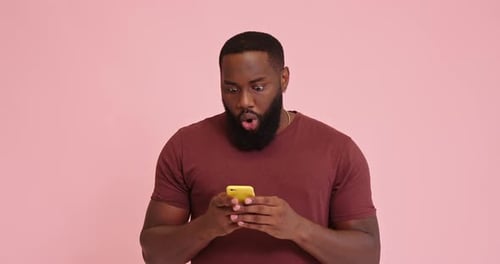 Man with Beard Looks Surprised at Mobile Phone