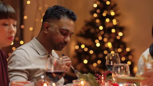 Friends Share Holiday Meal Together Near Christmas Tree