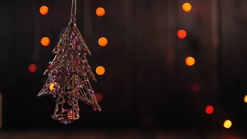 Christmas Shiny Toy in the Shape of a Christmas Tree on a Wooden Background