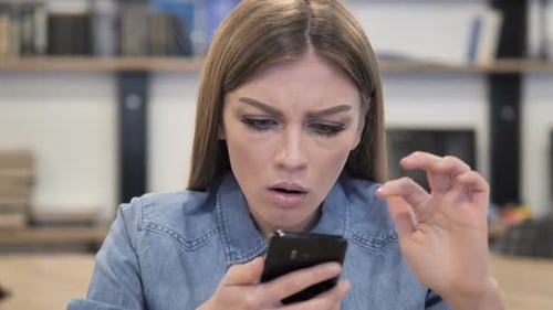 Woman Reacting with Shock While Using Mobile Phone
