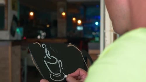Man Draws a Chalk on a Black Board