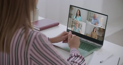 Back View of Female Employee Speak Talk on Video Call with Diverse Multiracial Colleagues on Online