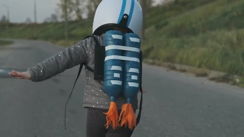 Jolie fille courant sur une route rurale portant un casque et un jetpack, agissant pour être pilote