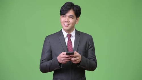 Young Adult Smiling Wearing Suit Using Cellphone