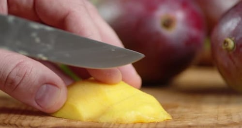 Slicing Ripe Mango on Cutting Board Close Up