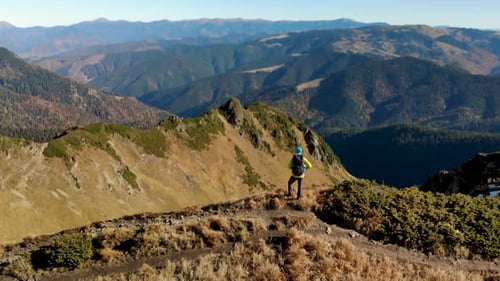 Aerial Unveil Mountain Valley with Man Hiker Standing on Ridge