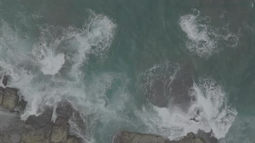 Waves Crash Against Rocks in the Ocean