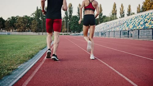 Back View Fitness Couple Running on Urban Stadium Together