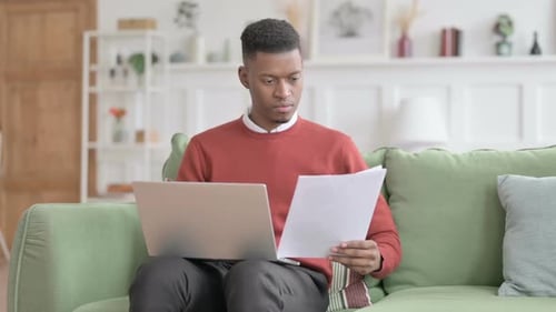 Young Adult Working on Laptop at Home