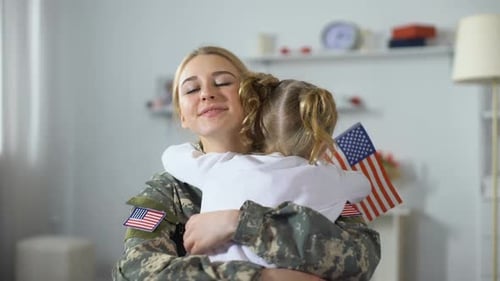 Child Hugs Military Mother Holding American Flag
