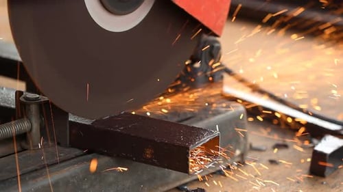 Arbeiter schneidet Metall und Funken mit einer Schneidemaschine