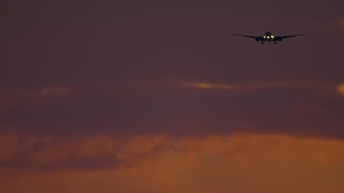 Verkehrsflugzeug nähert sich dem Flughafen über dem Meer bei dunklem Himmel.