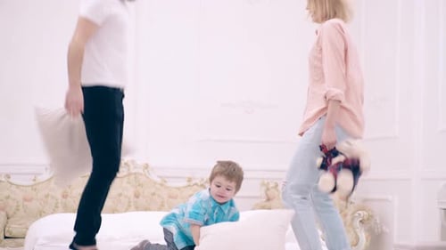 Family Plays on Bed in Bright Bedroom