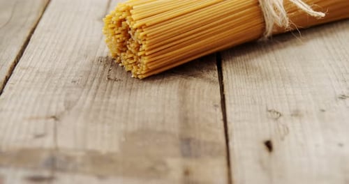 Uncooked Spaghetti Tied on Wooden Surface