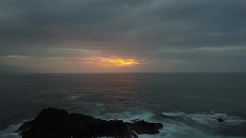 Slow Backward Flight Above Stormy Ocean Towards Beautiful Colourful Sunset. Aerial Drone Shot of