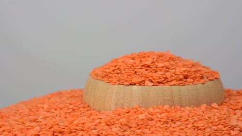 Raw organic red lentils grains on white background, close view.