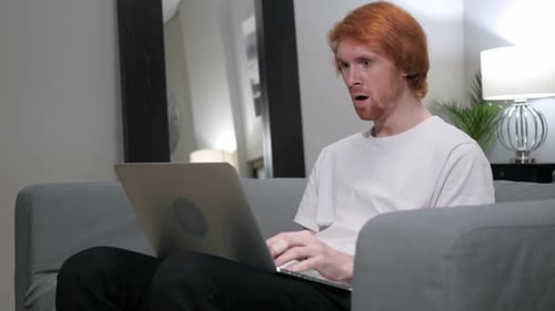 Man Expresses Shock at Laptop in Home