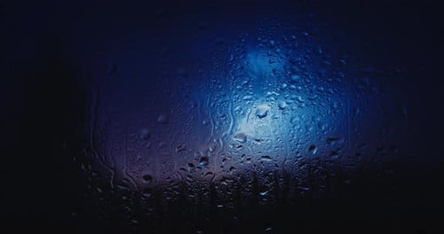 Regentropfen auf Glas. Gewitter im Hintergrund