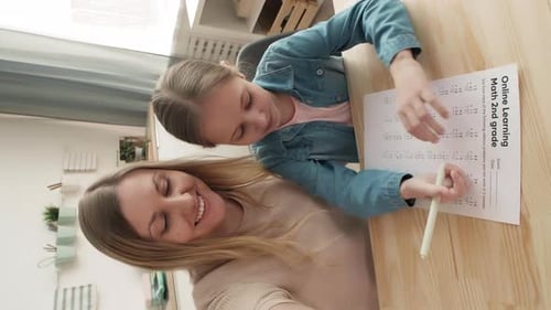 Woman Helping Child with School Math at Home
