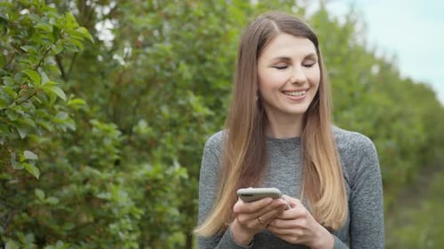 Happy Young Woman Use Smartphone Standing in Park Sun Outdoor Health Hand Girl
