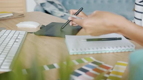 Graphic Designer Using Tablet at Desk