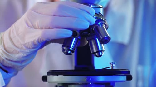 Professioneller Wissenschaftler schaut durch Mikroskop und untersucht neue Bakterientypen