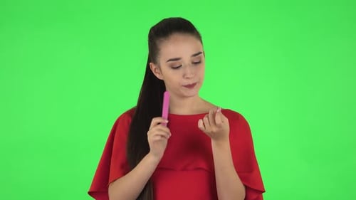 Portrait of Pretty Young Woman Is Making Herself Manicure with Pink Nail File. Green Screen