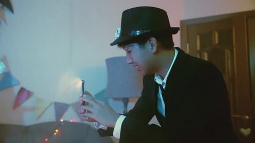 Un chico toma fotos o toma fotos en el teléfono de sus amigos en Halloween