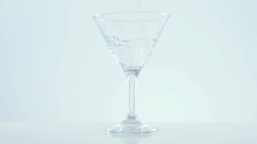 Clear Liquid Being Poured Into a Martini Glass