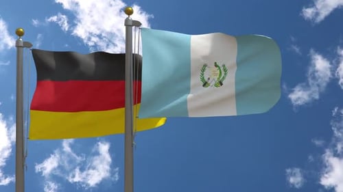 Germany and Guatemala National Flags Waving on Flagpoles