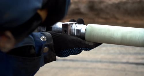 Close Up Footage of Two Men Connecting Pipes Together Breaking the Spacers