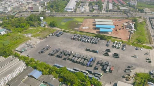 Aerial top view of truck cars parking stock lot row in industry factory, dealer inventory import
